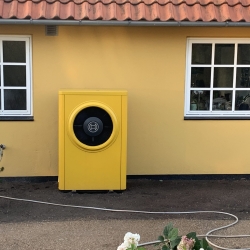 Udendørs Bosch varmepumpe installeret ved gul villa i Hørve – energivenlig løsning til helårshus