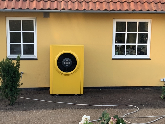 Udendørs Bosch varmepumpe installeret ved gul villa i Hørve – energivenlig løsning til helårshus